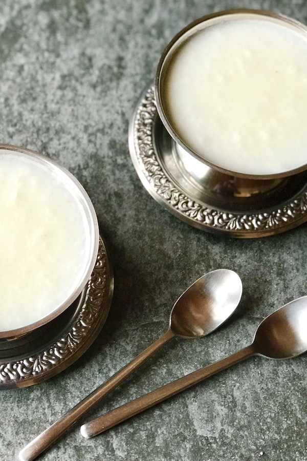 Coconut dessert in 2 round silver bowls and 2 teaspoons