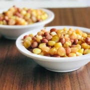 Two white bowls with boiled corn and groundnuts