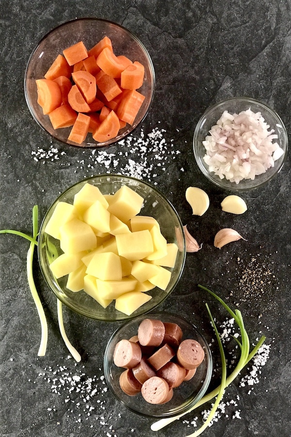 ingredients for a hearty one-pot or Eintopf, carrots, onions, potatoes, garlic, spring onions