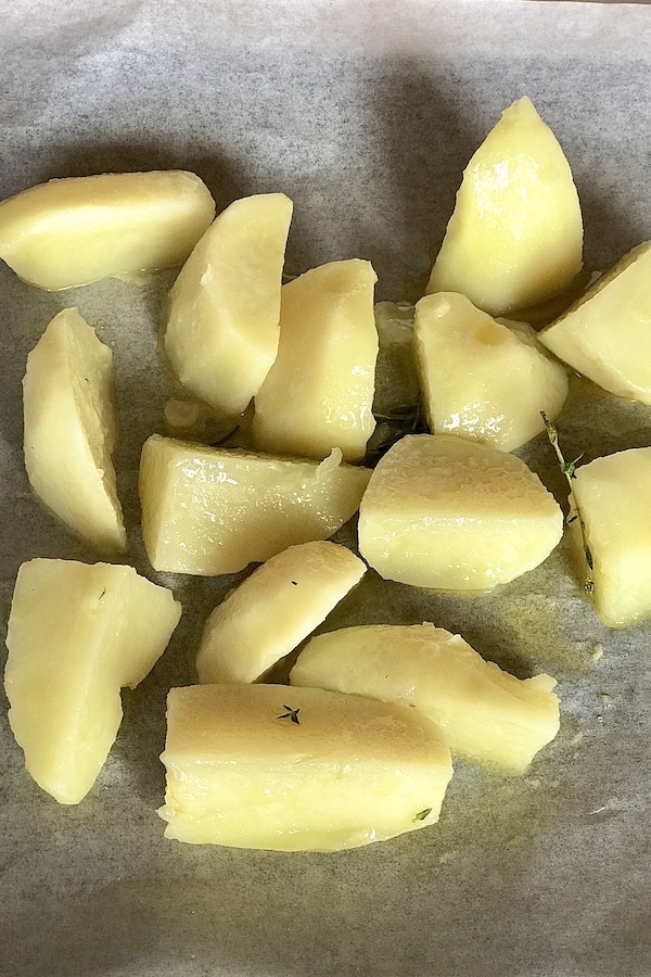 Cooked quartered potatoes on white baking paper