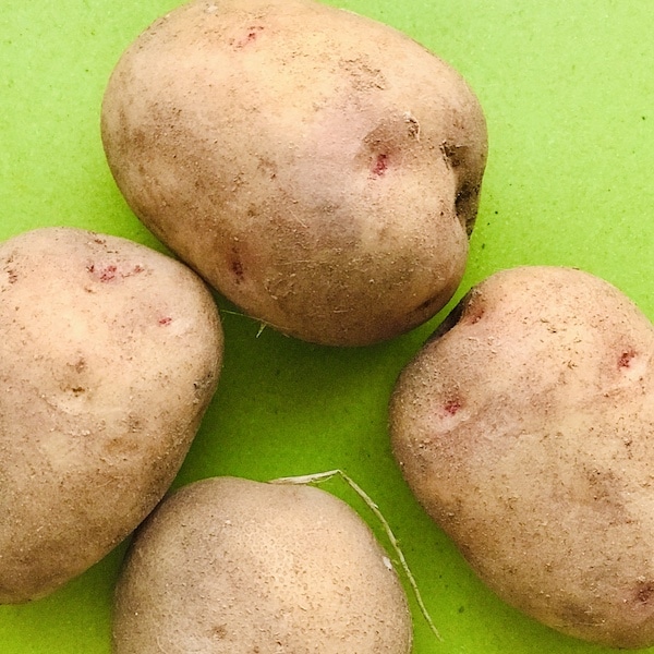4 potatoes on a green board
