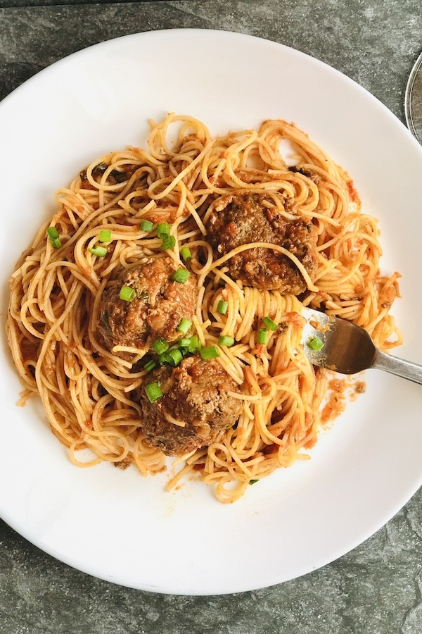 Meatballs and Spagehtti with spring onion garnish