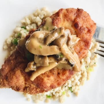 Chicken Schnitzel with mushroom peppercorn sauce on steamed fonio