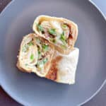 3 cut chicken wrap halves on a round plate.