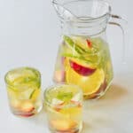 White wine sangria in a glass jug and two glasses