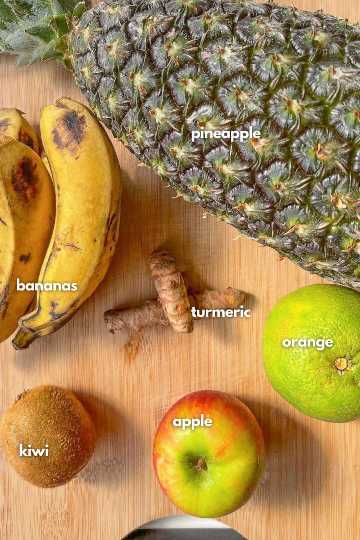 Ingredients for turmeric smoothie: pineapple, bananas, kiwi, orange, apple and fresh turmeric