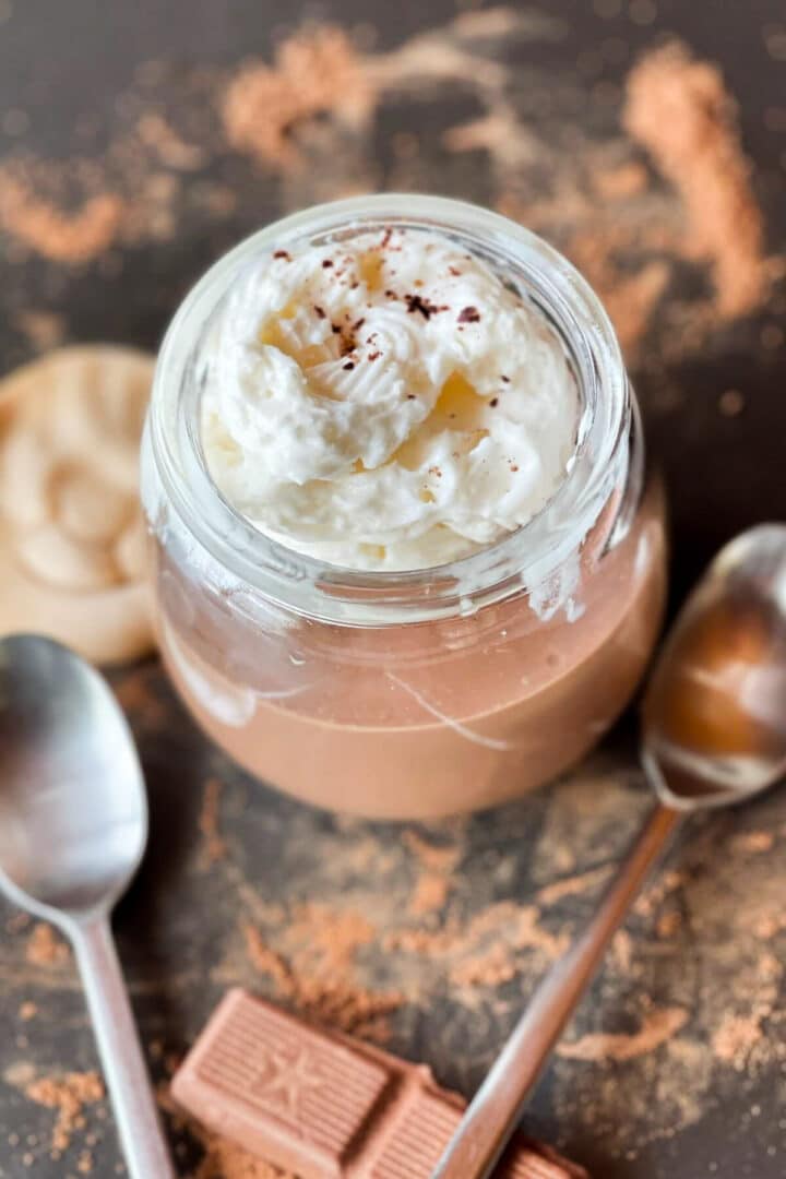 Glass jar with chocolate pudding and whipped cream on top