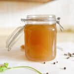 Beef stock in a large glass jar.
