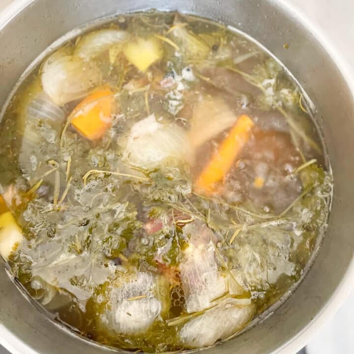Beef stock simmering in silver pot.