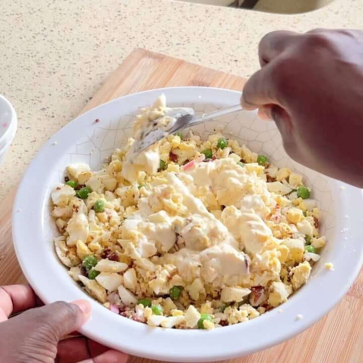 Mixing mayonnaise into egg salad.