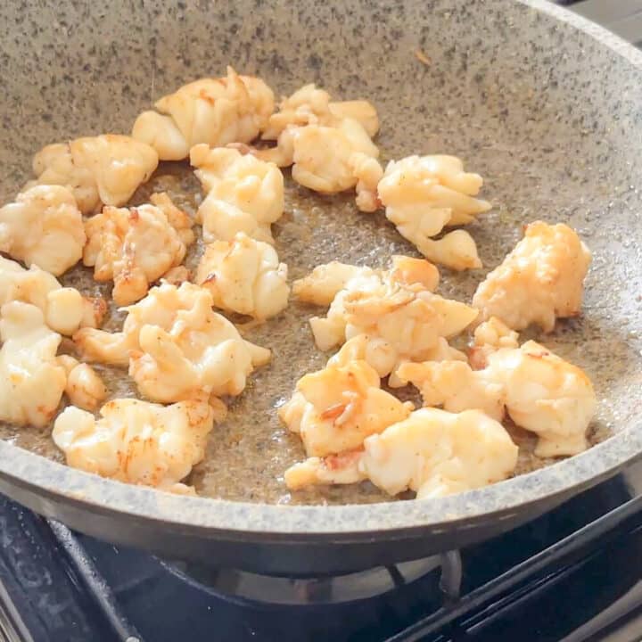 Lobster pieces frying in a pan.