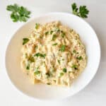 Egg salad in a round white ceramic bowl.