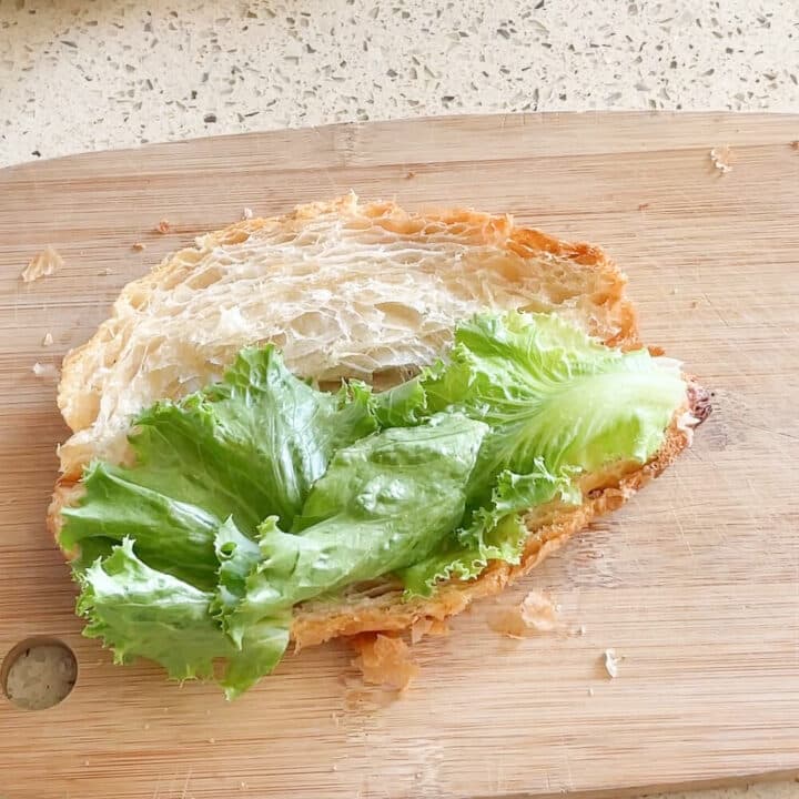 Lettuce on a sliced croissant.