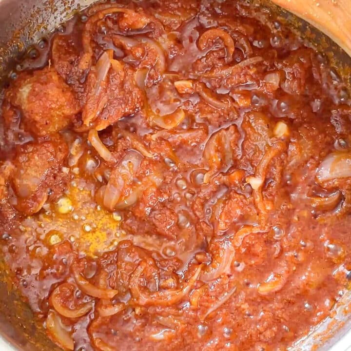Fried onions and tomato paste in a pot.
