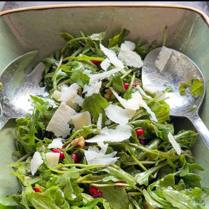 Arugula salad with pomegranate seeds and parmesan shavings.
